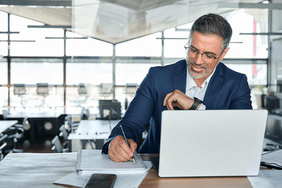 Business man working on laptop and taking notes