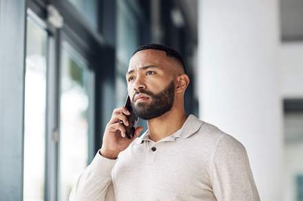 Man on the phone contacting help to report a cybersecurity attack.