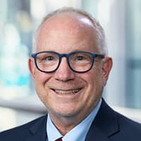 man in glasses smiling at camera