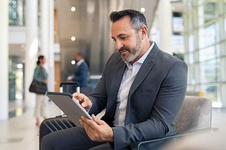 Businessman on his tablet at the aiport.