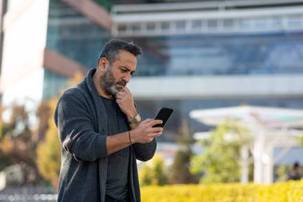 Concerned man looking at his mobile phone.
