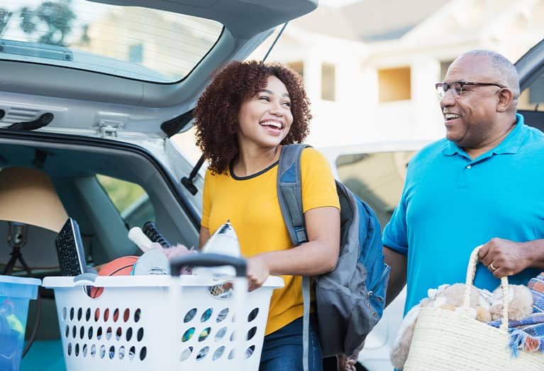 Father helping daughter pack for college