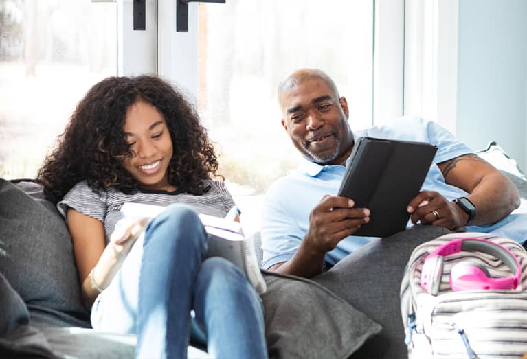 Father helping teen daughter with homework