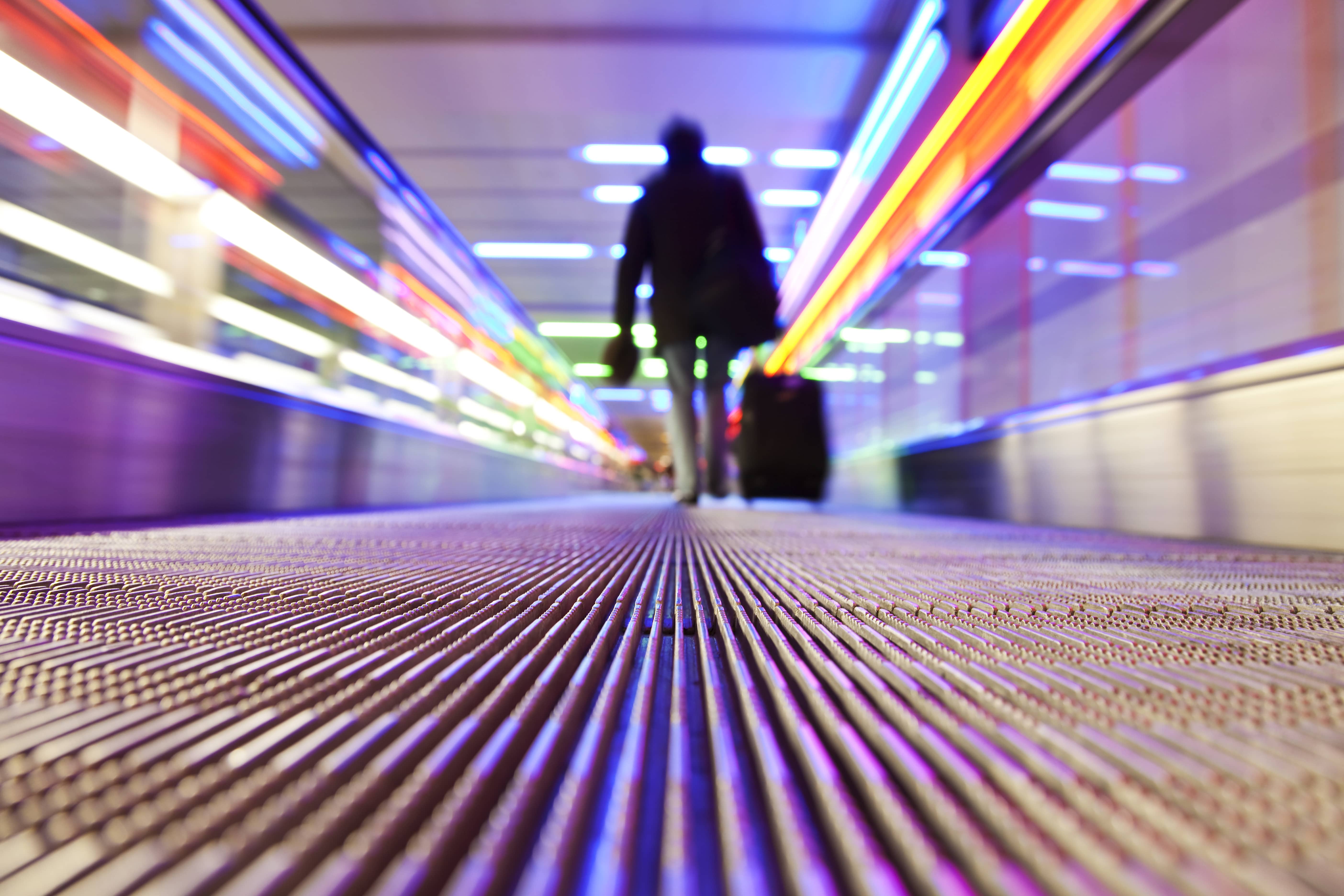 Businessperson traveling on a flat escalator.