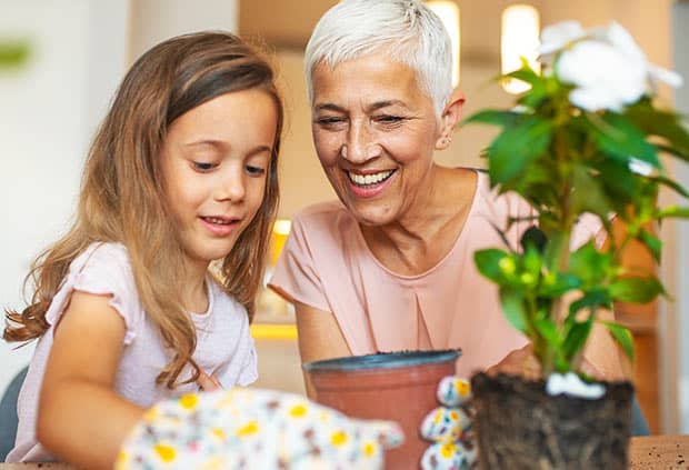 grandmother and granddaughter potting a plant