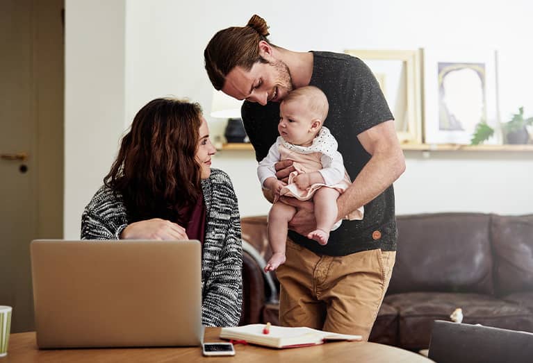 Husband and wife bonding with their baby at home