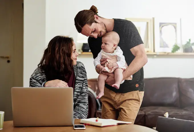 Husband and wife bonding with their baby at home