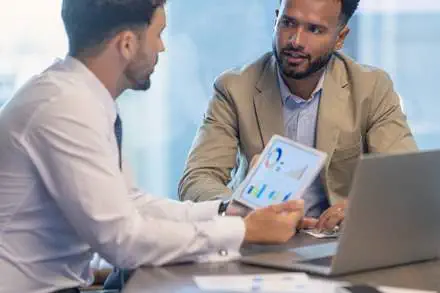 two people discussing investment charts