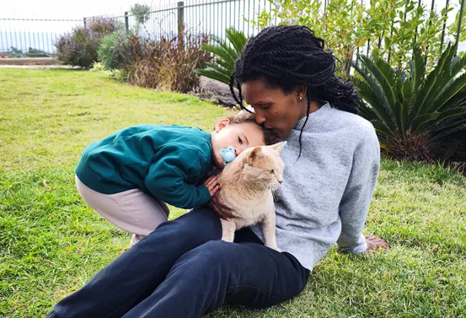 Mother sitting outside with her daughter and cat thinking about life insurance protection