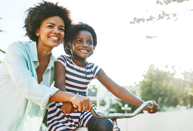 mother helping daughter ride bike