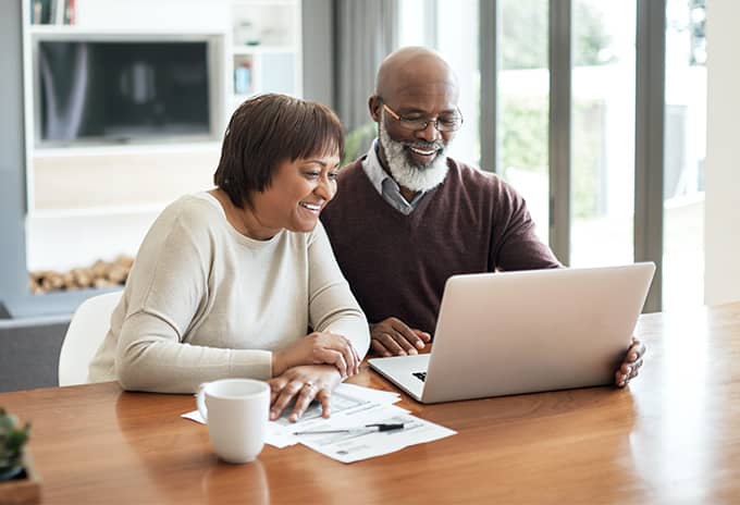 Pre-retiree couple researching annuities on computer