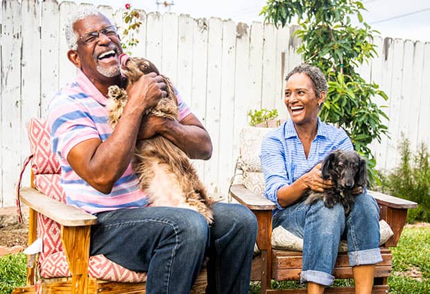 senior couple playing with dogs talking about retirement