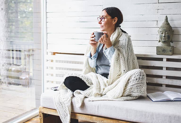 woman drinking coffee looking out