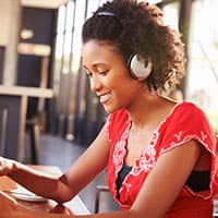 young woman using ipad and headphones