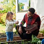 Father gardening with daughter thinking about the future