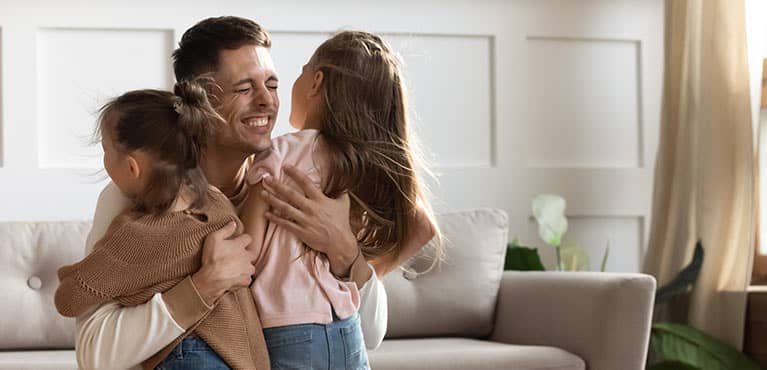 Father hugging his children