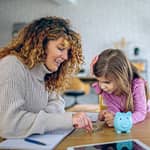 Mother teaching daughter about money