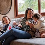 Mother relaxing on the couch with her two daughters