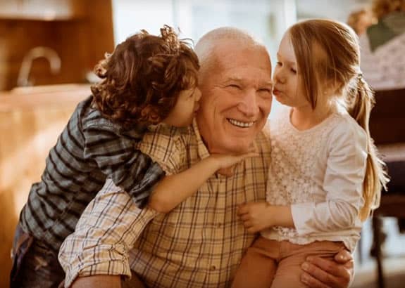 grandfather with two grandchildren feeling happy he has a policy with western & southern financial group