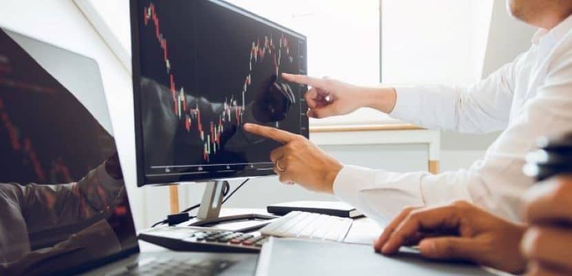 Portfolio managers discussing analysis with profit from the screen stock on the computer in the office.