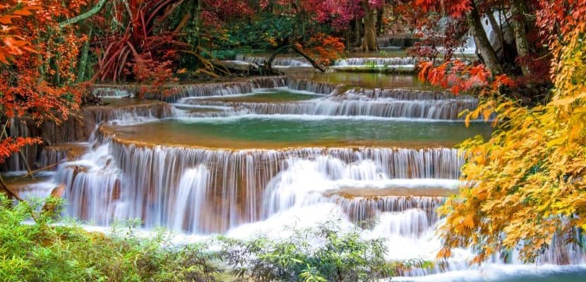 Cascading waterfalls surrounded by vibrant autumn colors.