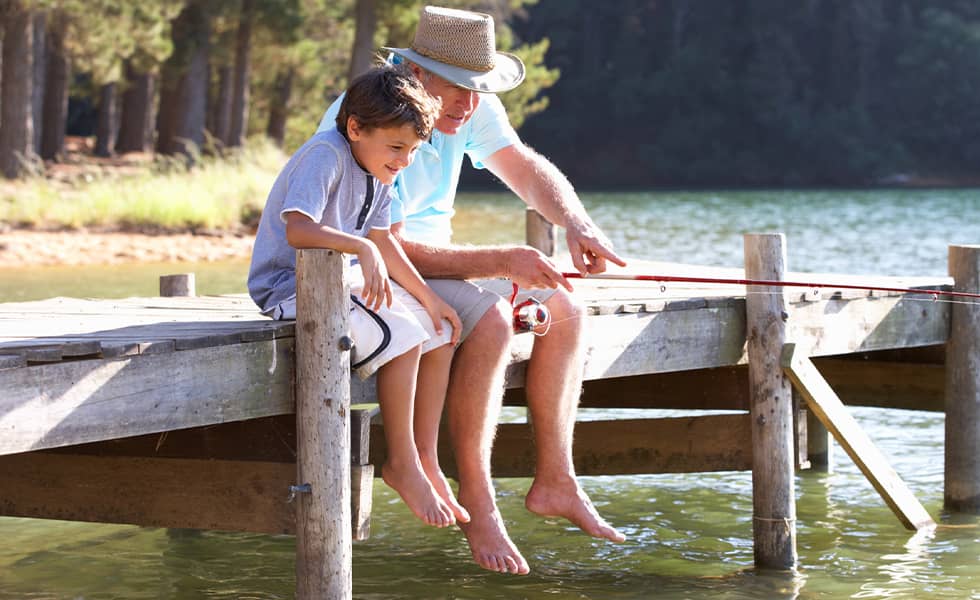 Grandfather and grandson fishing at lake