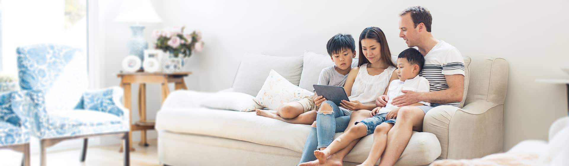 Family sitting together on couch with tablet