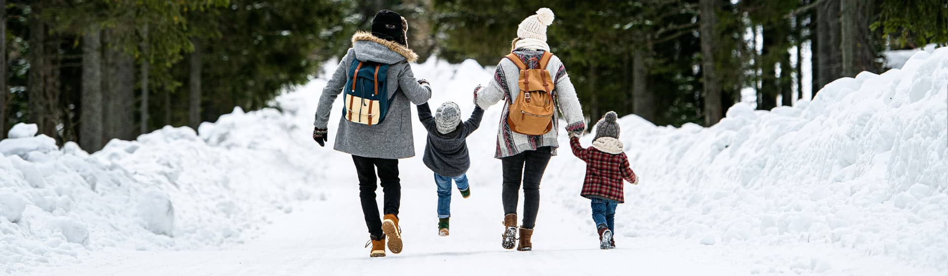 Family with two small children walking in winter nature knowing they're financially secure.