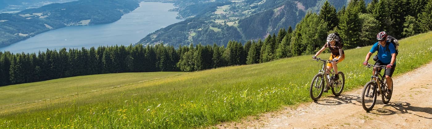 two cyclists on a path near a river