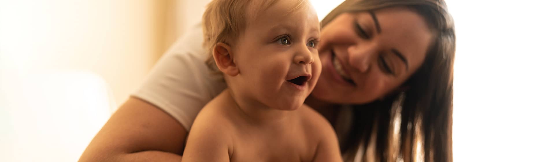 Mother cradling baby son on her shoulder
