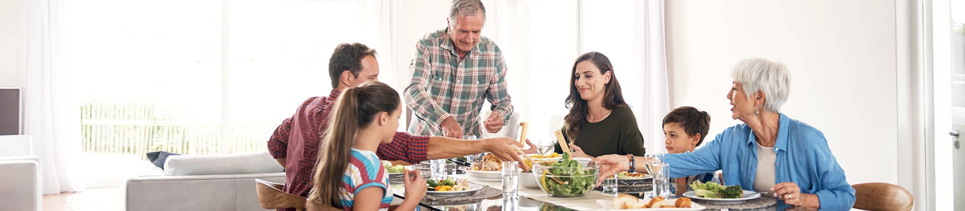 clic multi generational family eating dinner at table