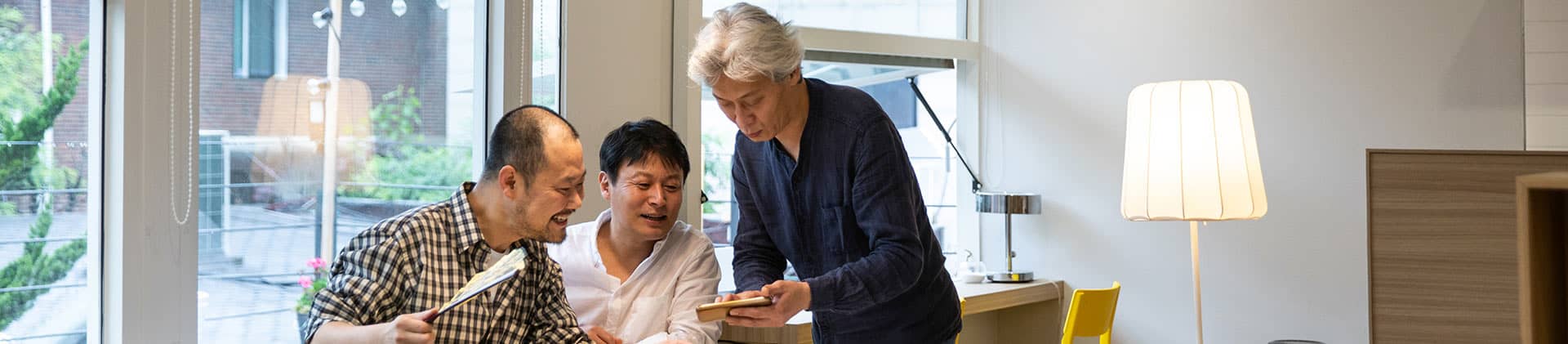 3 generation of men using their cell phone to get information