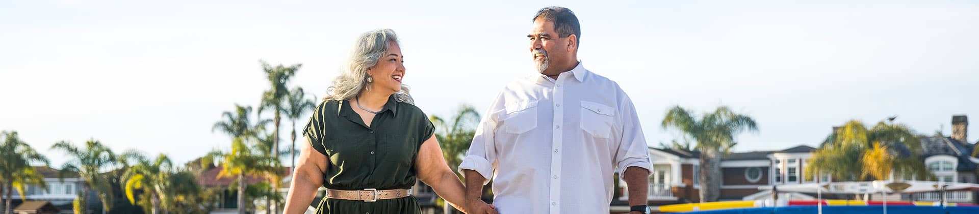 A couple holding hands walking in the harbor 