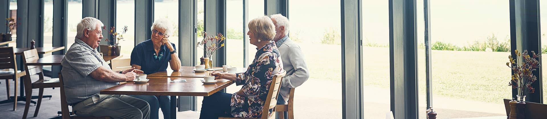 2 older couples sitting at a table having a discussion 
