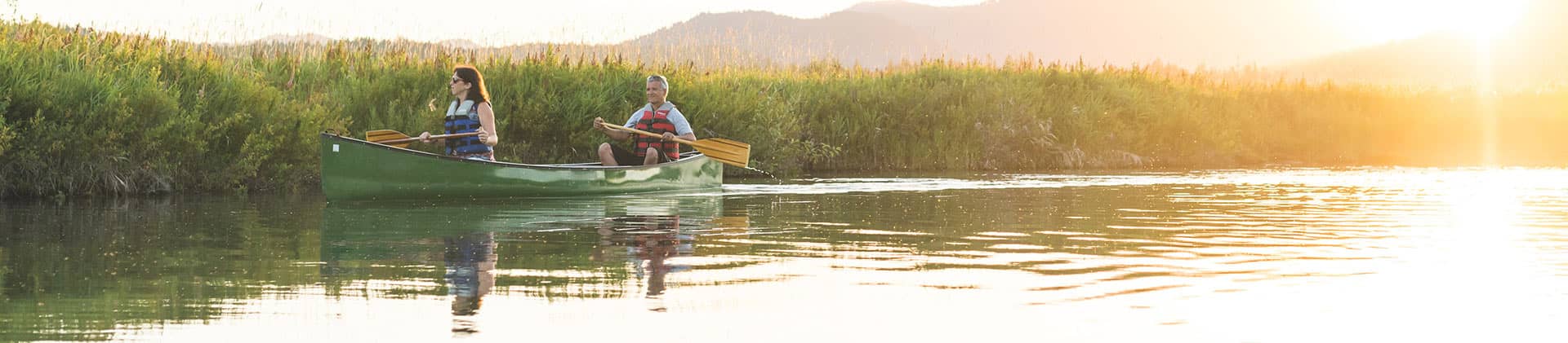 woman and man couple canoeing on lake in mountains talking about new momentum flexible premium deferred annuity and annuities