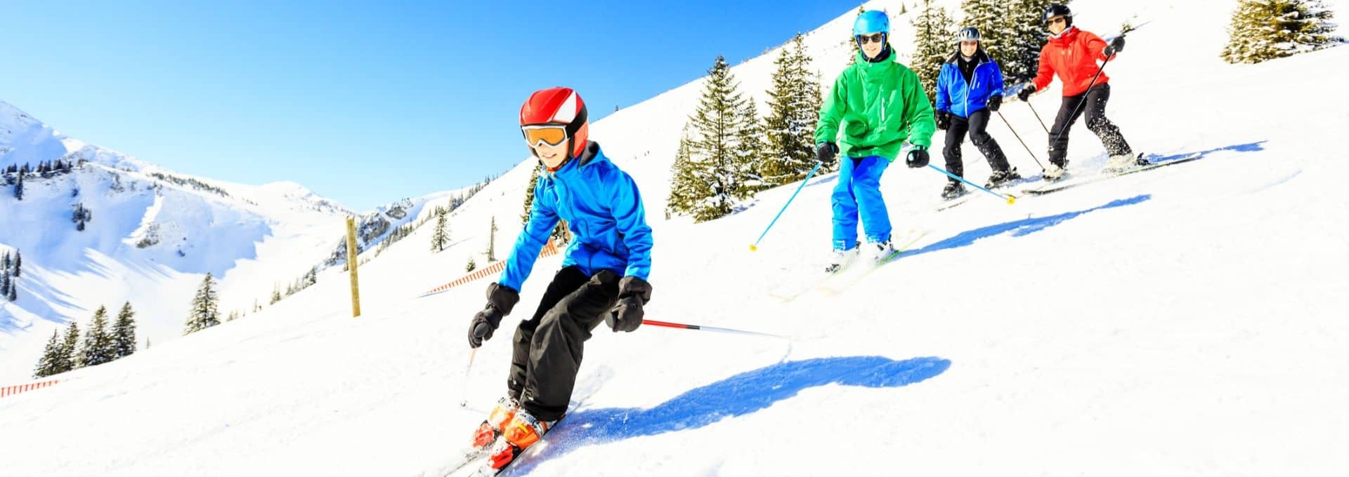 Family of four skiing at ski resort.