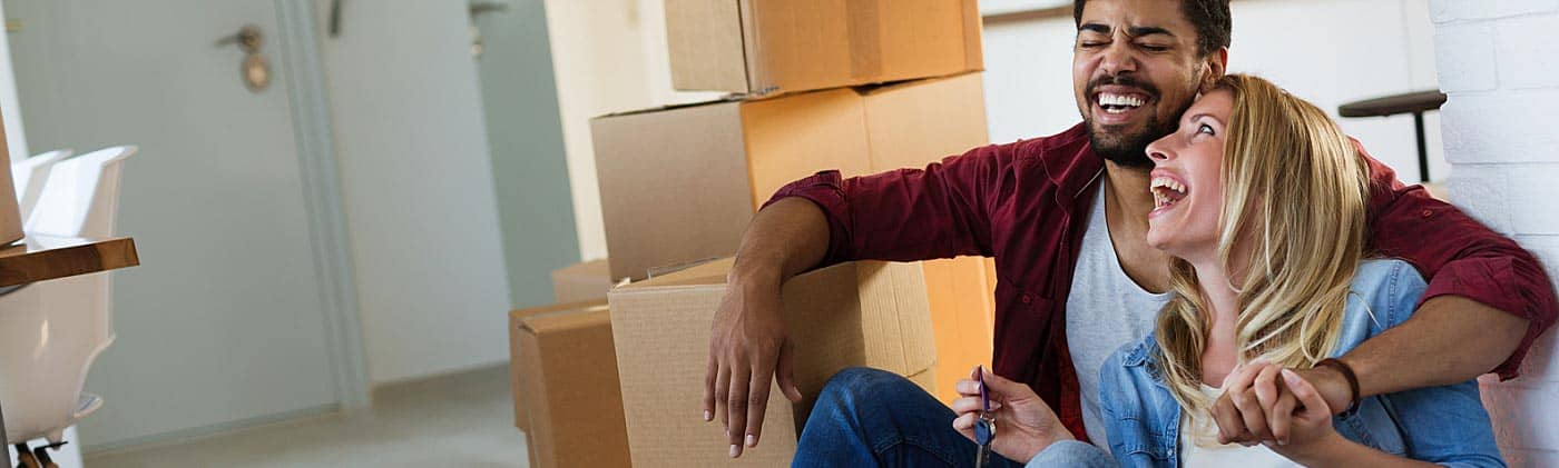 A couple laughs inside the kitchen of their new home: buying your first home