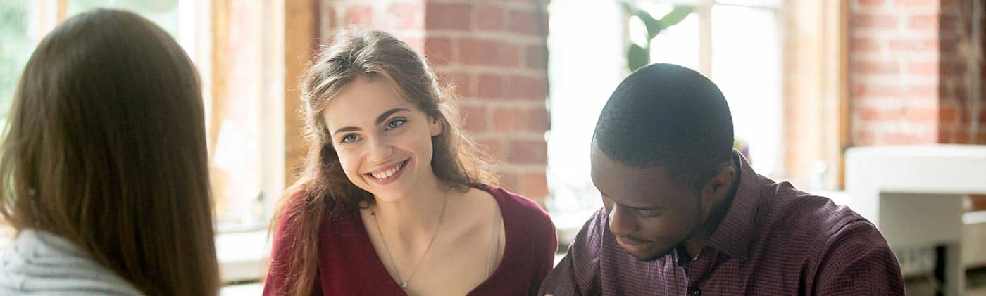 young couple signs paperwork for their first home with realtor and celebrates their SMART goal setting