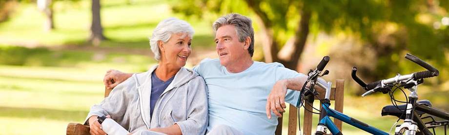 A couple sits on a park bench and discusses changing their medicare supplement insurance plan 