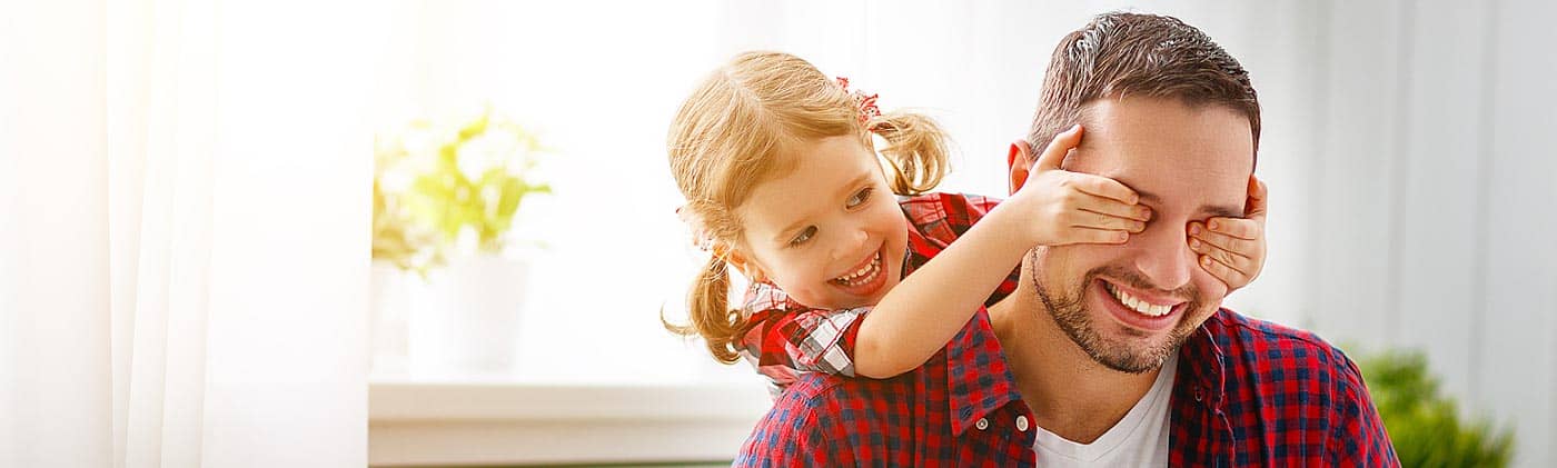 A father plays a game with his young daughter at home: accidental death insurance