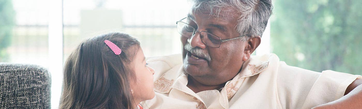 grandfather looks lovingly at his granddaughter as he considers buying multiple life insurance policies