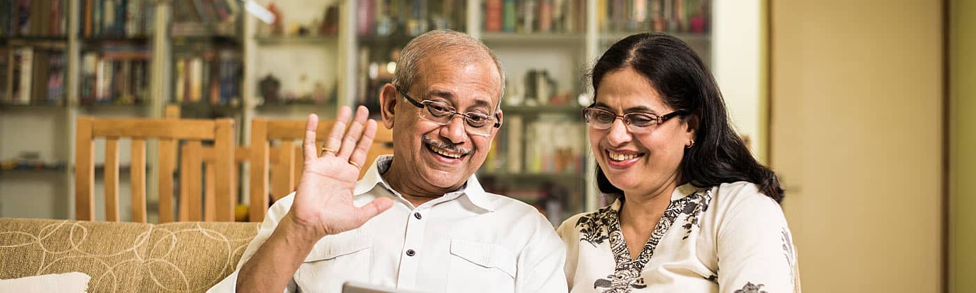 A happy couple sitting on a couch discusses what to do in retirement 