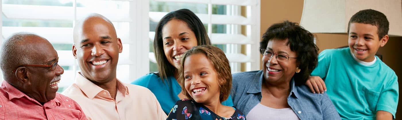 A happy family sharing the couch in a living room wondering is life insurance taxable 
