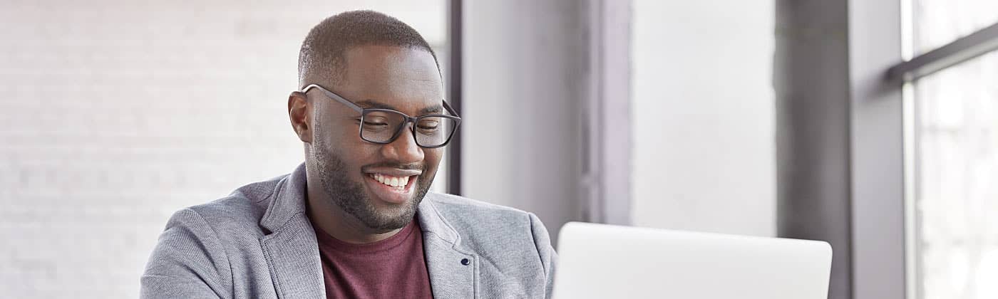 A happy man filing his taxes on a laptop 