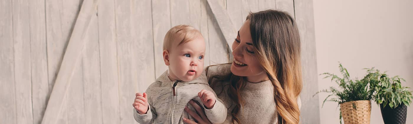 happy mother at home holds her child she adopted with financial help from the adoption tax credit