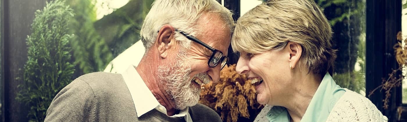 A happy older couple smiles and laughs after purchasing a flexible premium deferred annuity 