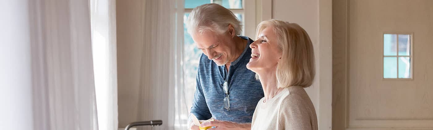 A mature couple discusses their living trust while cooking dinner 