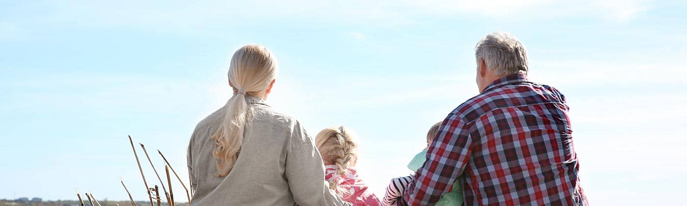 grandparents sit by a lake with their two grandkids and are happy they invested in a traditional ira