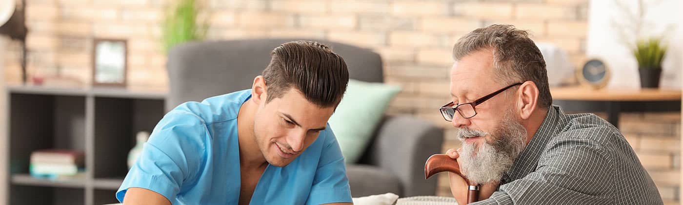 mature man with cane plays chess with male caregiver and reflects on costs of long-term care