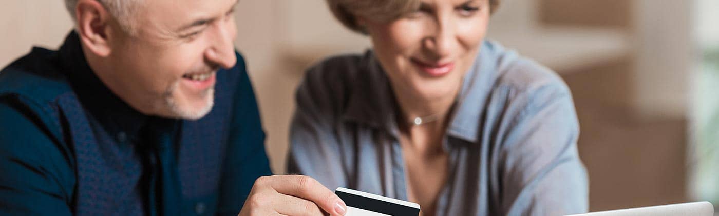 A middle-aged couple making a purchase with their credit card: credit card debt